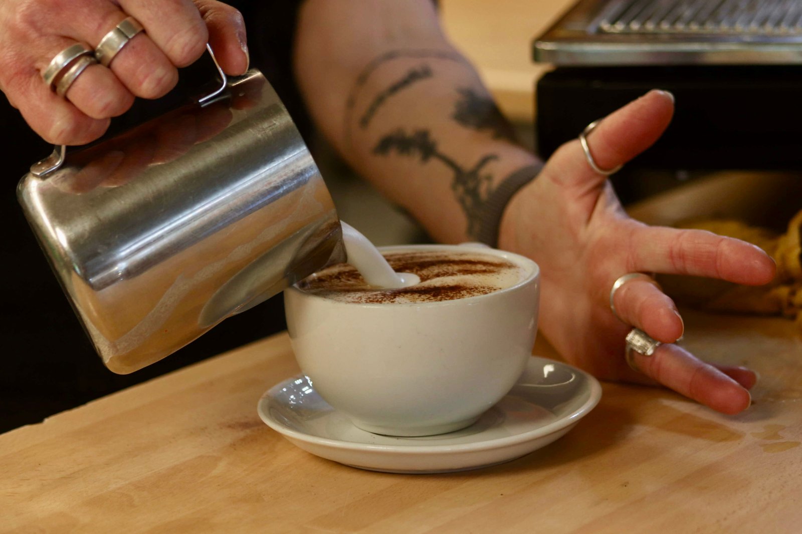 A Caffi Siabod barista pouring latte art